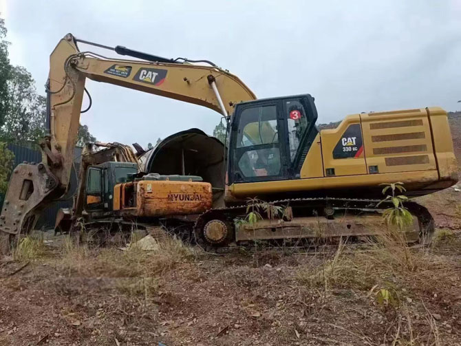 Cat 330 excavator with hydraulic breaker working on construction site